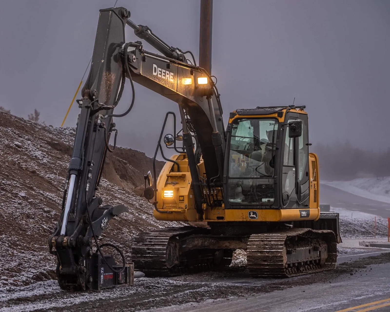 A Steele Earthworks excavator working at dusk