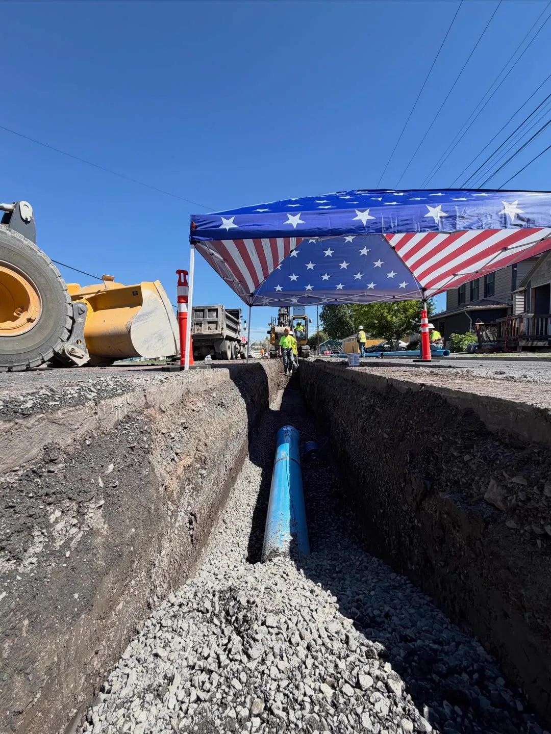 Open trench with new blue water main laid down a Burns, Oregon street by Steele Earthworks