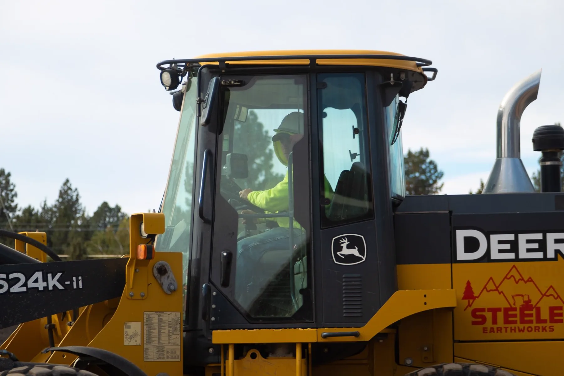 A Steele Earthworks operator running a branded loader